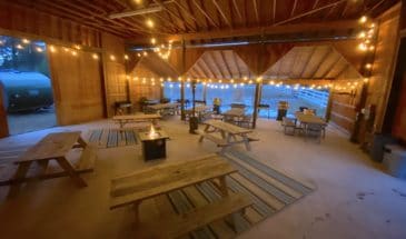 View of event space with picnic tables and a campfire burning in the middle