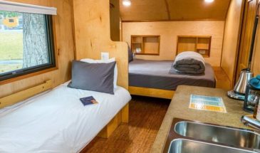 View inside a trailer cabin with two beds and a small kitchen